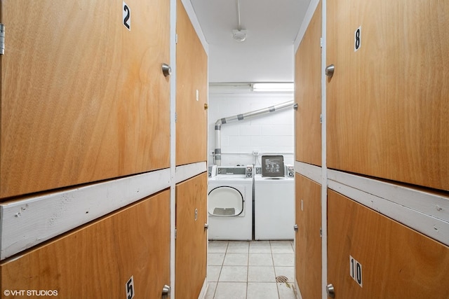 laundry room featuring laundry area, washer and clothes dryer, and light tile patterned flooring