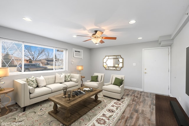 living room featuring baseboards, a ceiling fan, a wall unit AC, wood finished floors, and recessed lighting