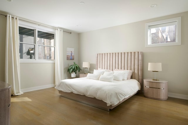 bedroom with baseboards and wood finished floors