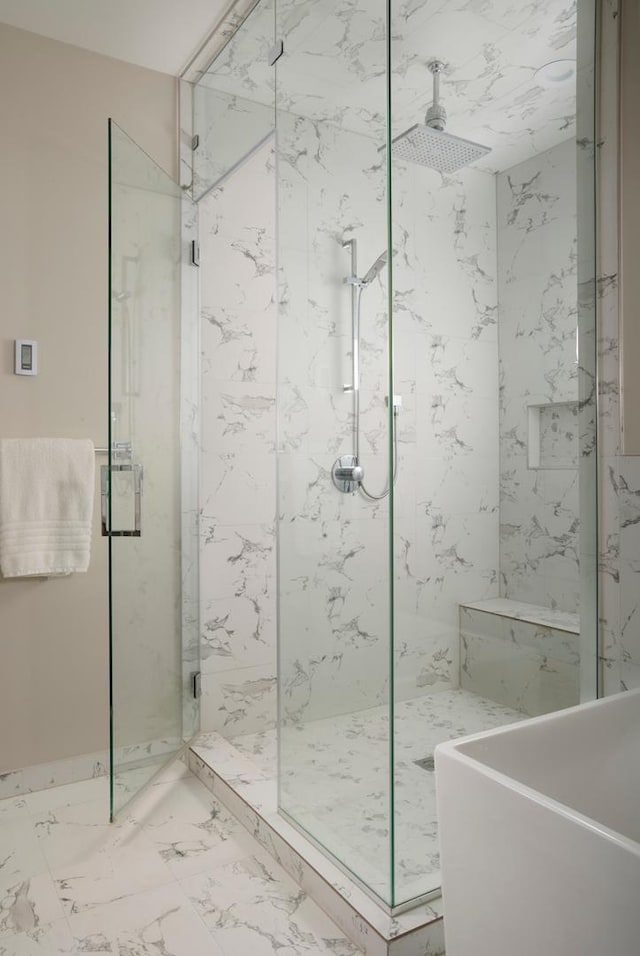 full bathroom featuring marble finish floor, a sink, and a marble finish shower