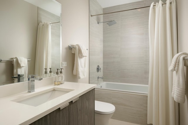 bathroom with tiled shower / bath, vanity, and toilet