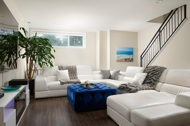 living area featuring dark wood-type flooring and stairs