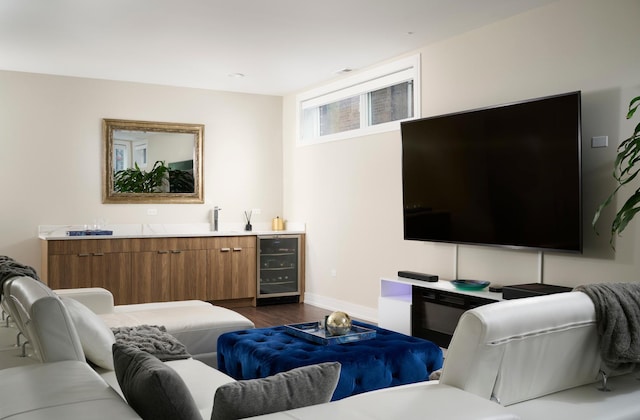 living room with wine cooler, baseboards, dark wood finished floors, and indoor wet bar