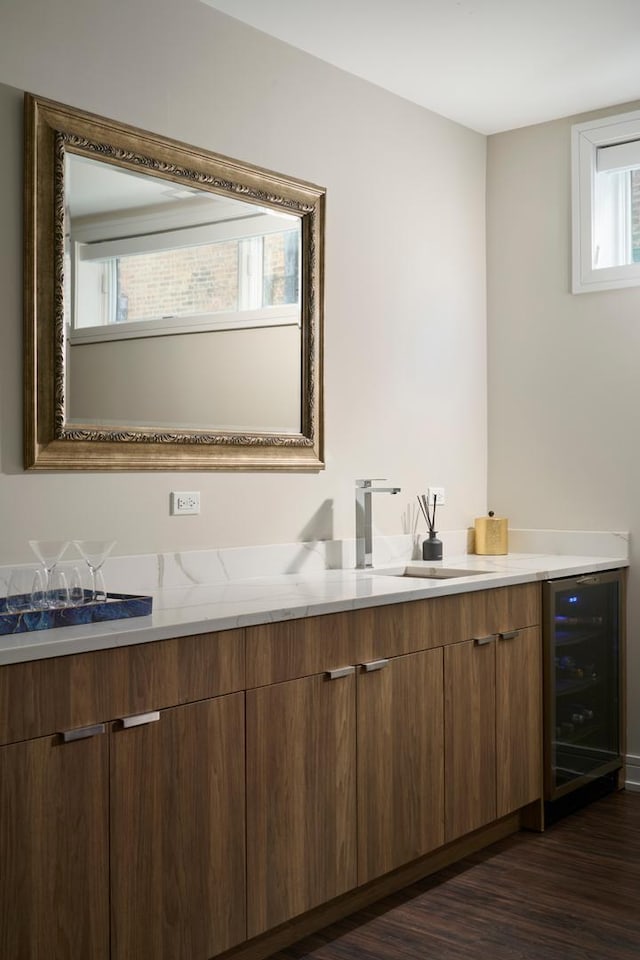 bathroom with double vanity, beverage cooler, a sink, and wood finished floors