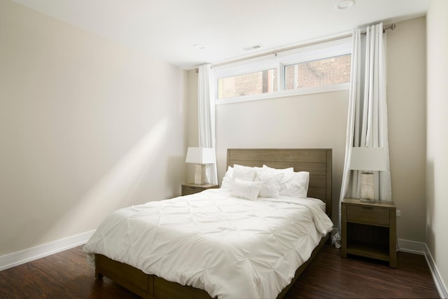 bedroom featuring dark wood-type flooring, visible vents, and baseboards