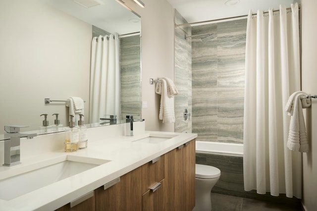 bathroom featuring a sink, tiled shower / bath combo, toilet, and double vanity