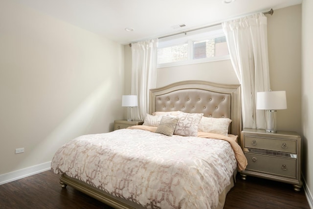 bedroom featuring baseboards, visible vents, and wood finished floors