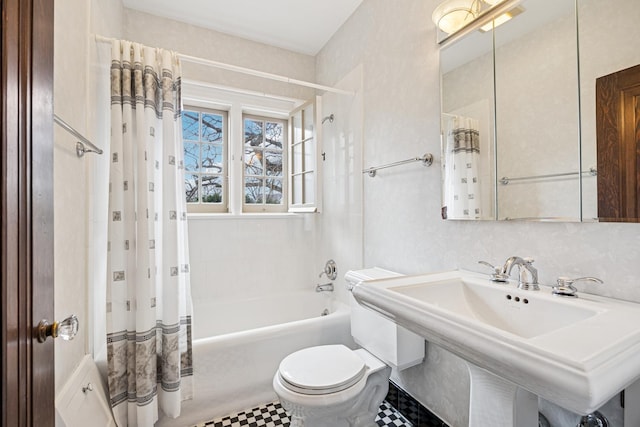 bathroom with a sink, toilet, and shower / tub combo with curtain