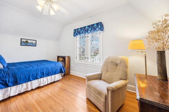 bedroom featuring baseboards, a ceiling fan, hardwood / wood-style floors, and vaulted ceiling
