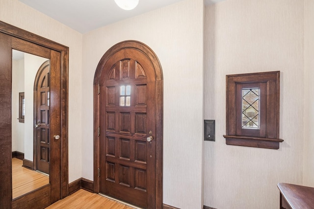 foyer entrance featuring light wood-style flooring and baseboards