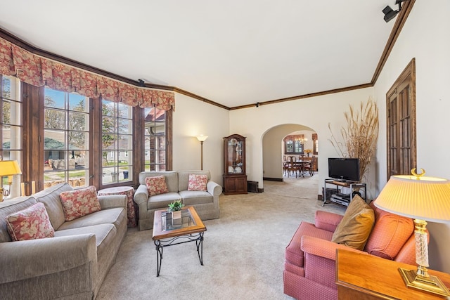 carpeted living area featuring arched walkways and crown molding