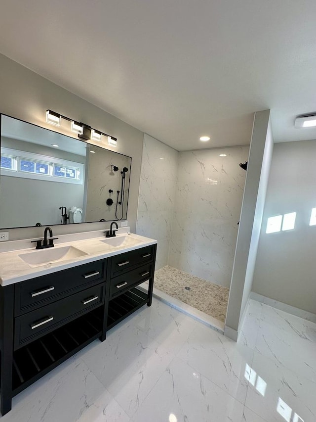 bathroom featuring marble finish floor, double vanity, a sink, and a marble finish shower