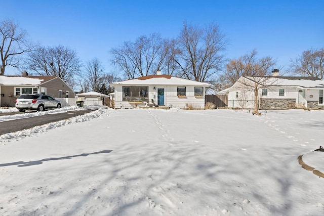 bungalow-style house featuring a detached garage, fence, and a residential view