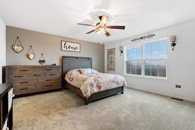 bedroom featuring carpet floors, a ceiling fan, visible vents, and baseboards