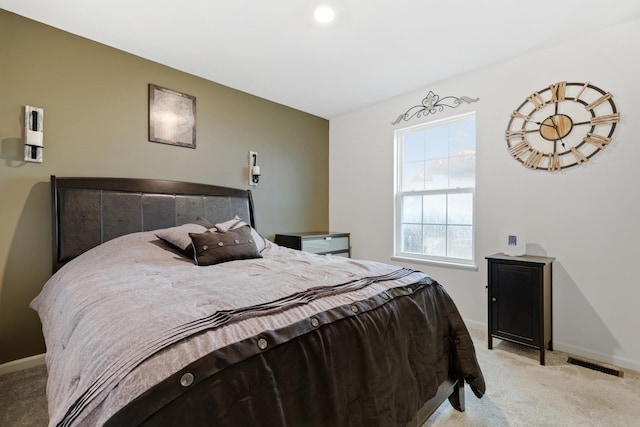 bedroom featuring visible vents, light carpet, and baseboards