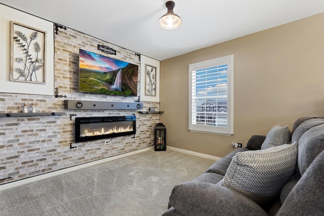 living area featuring carpet, baseboards, a glass covered fireplace, and brick wall