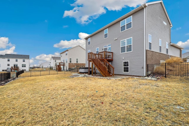 back of house featuring brick siding, a lawn, stairway, a deck, and a fenced backyard