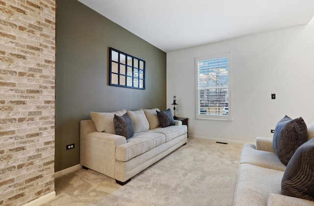 living area featuring light colored carpet, visible vents, and baseboards