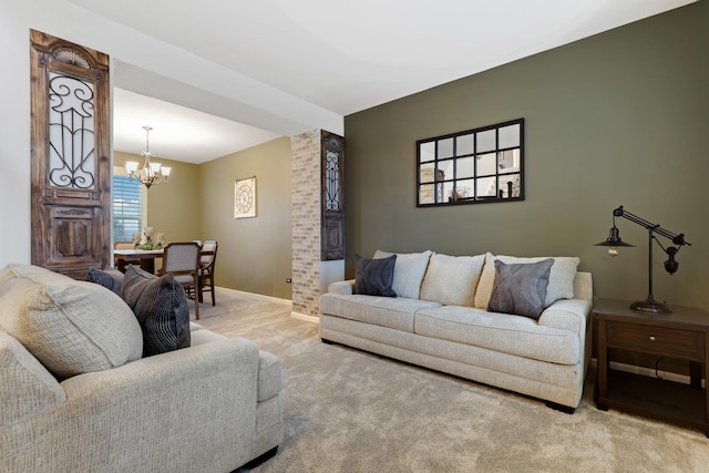 living room with an inviting chandelier, baseboards, and carpet flooring