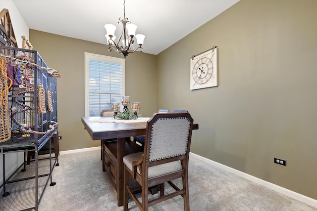 dining room with baseboards, a notable chandelier, and light colored carpet