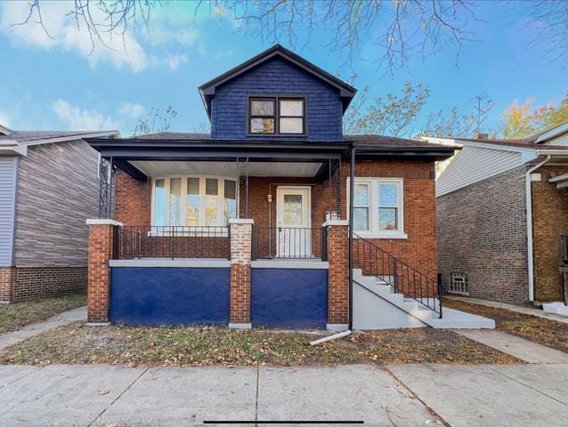 bungalow featuring a porch and brick siding