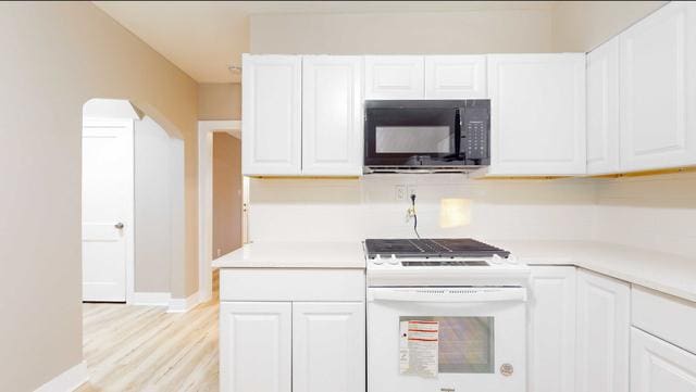 kitchen featuring black microwave, light countertops, white range oven, and white cabinetry