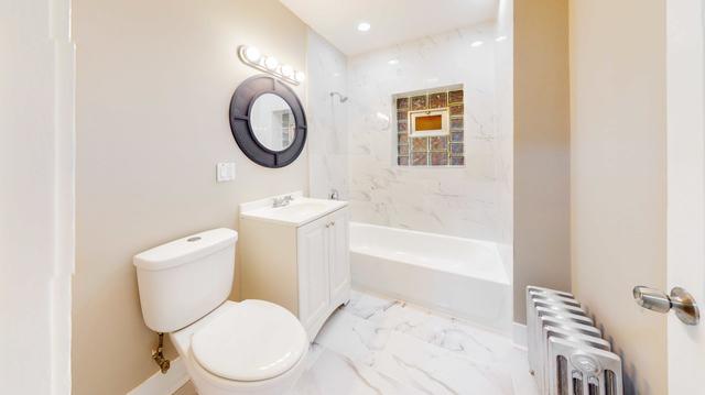 bathroom with toilet, radiator heating unit, marble finish floor, bathtub / shower combination, and vanity