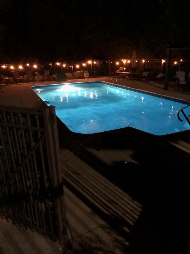 view of pool at twilight