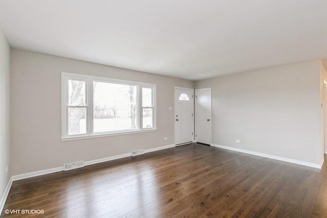 foyer entrance featuring dark wood-style flooring, visible vents, and baseboards