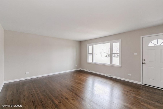 entrance foyer with visible vents, dark wood finished floors, and baseboards