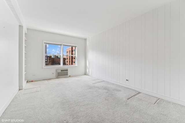 carpeted spare room with an AC wall unit