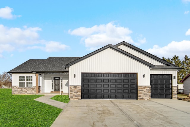 modern inspired farmhouse with an attached garage, concrete driveway, roof with shingles, a front lawn, and board and batten siding