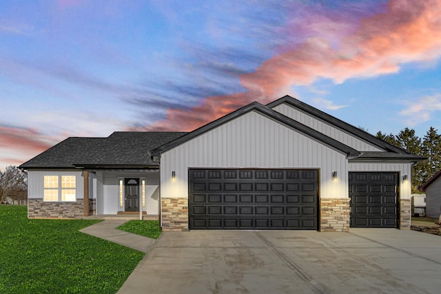 modern inspired farmhouse with a garage, stone siding, driveway, and roof with shingles