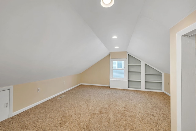 additional living space featuring baseboards, built in features, vaulted ceiling, carpet floors, and recessed lighting