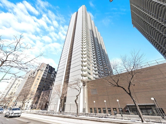 view of building exterior featuring fence and a city view