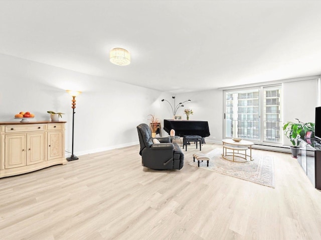 living room with baseboard heating, baseboards, and light wood finished floors