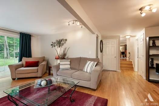 living room featuring light wood-type flooring and stairs