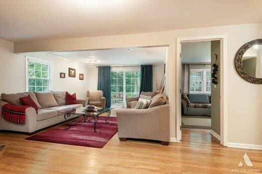 living area featuring light wood-type flooring, a wealth of natural light, and baseboards