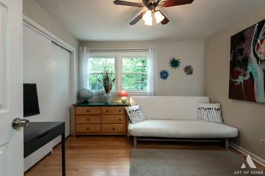 sitting room with light wood-style floors, baseboards, and a ceiling fan