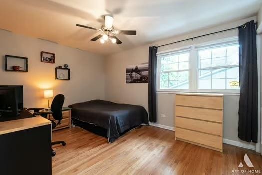 bedroom with a ceiling fan, baseboards, and light wood finished floors