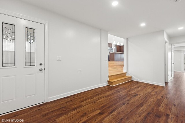 foyer entrance featuring dark wood-style floors, recessed lighting, baseboards, and stairs