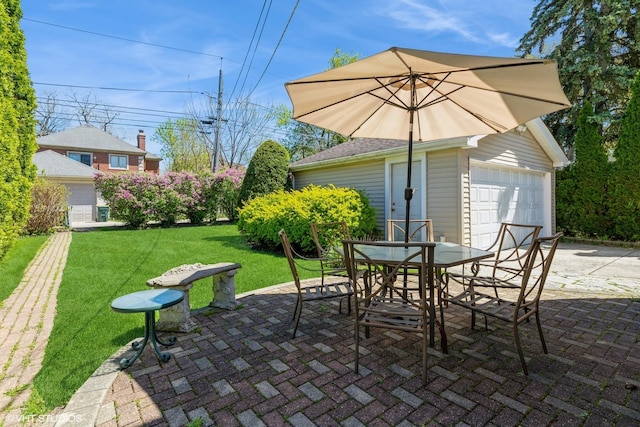 view of patio / terrace featuring a garage, outdoor dining area, and an outdoor structure