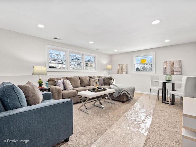 living area with baseboards, recessed lighting, plenty of natural light, and light colored carpet