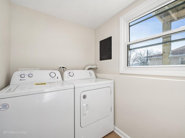 clothes washing area featuring laundry area, electric panel, baseboards, and washer and dryer