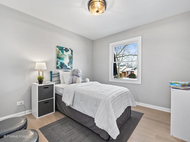 bedroom with light wood-type flooring and baseboards