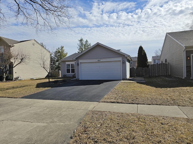 view of front of home featuring driveway, a garage, and fence