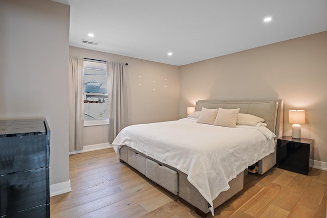 bedroom with light wood-style floors, recessed lighting, visible vents, and baseboards