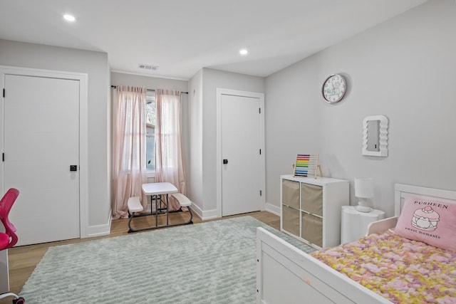 bedroom featuring baseboards, wood finished floors, visible vents, and recessed lighting