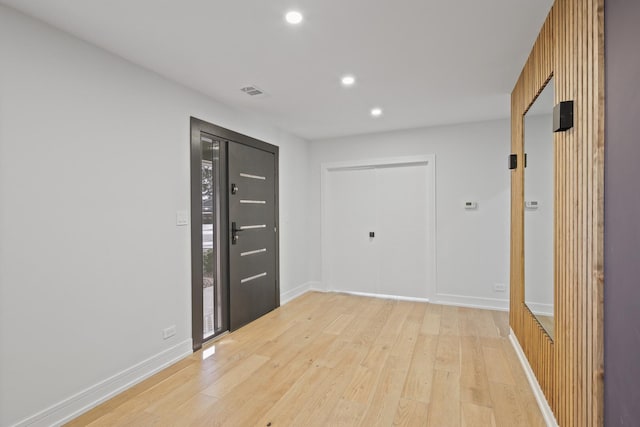 unfurnished room with recessed lighting, baseboards, visible vents, and light wood finished floors