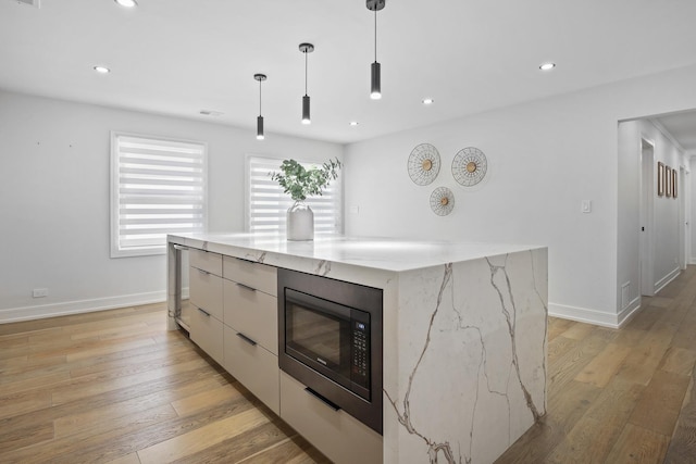 kitchen featuring built in microwave, recessed lighting, hanging light fixtures, modern cabinets, and light wood-type flooring